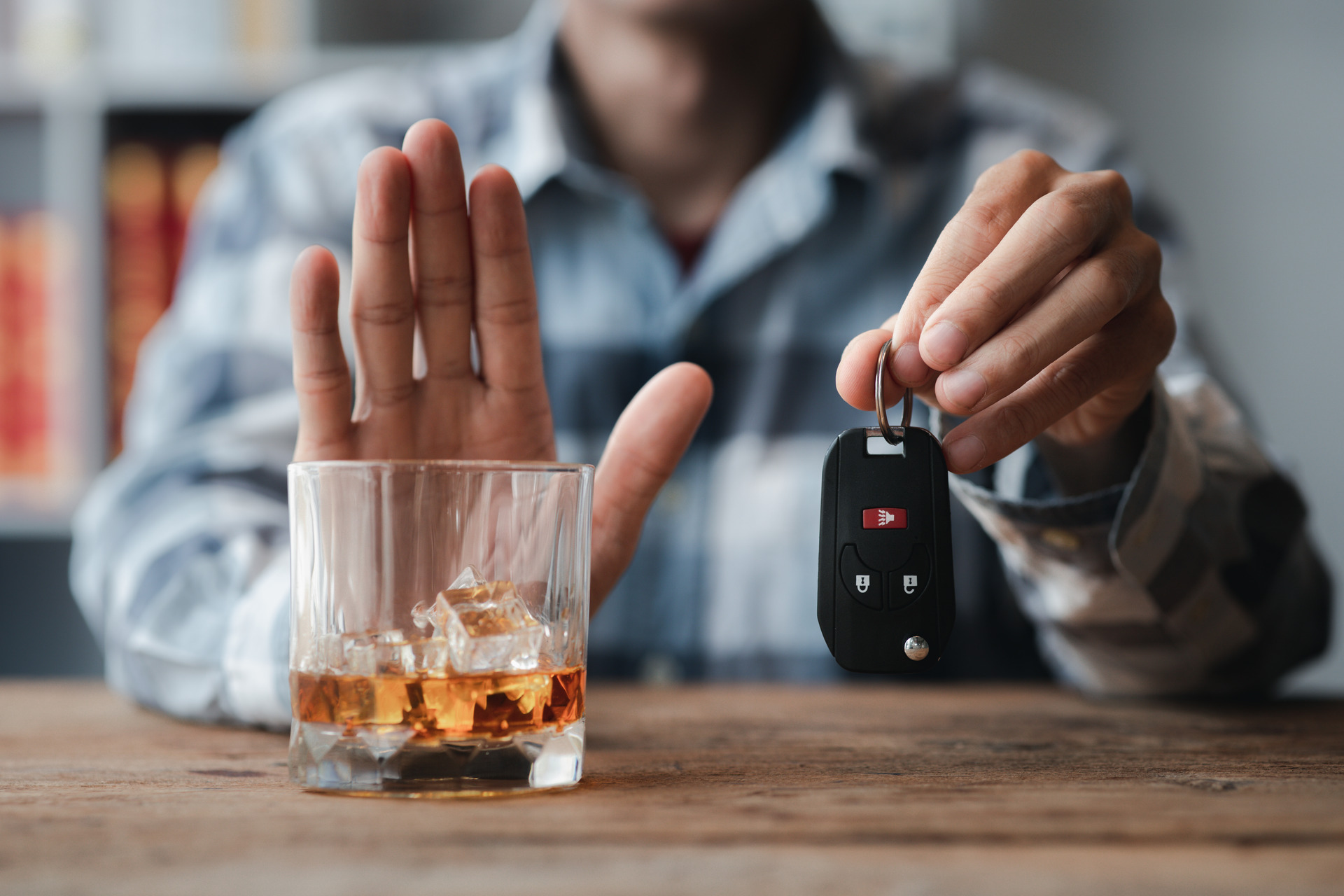 man showing stop to a glass of alcohol with his hand and holding car keys in the other