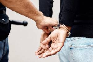 a policeman and handcuffs on criminal for arrest
