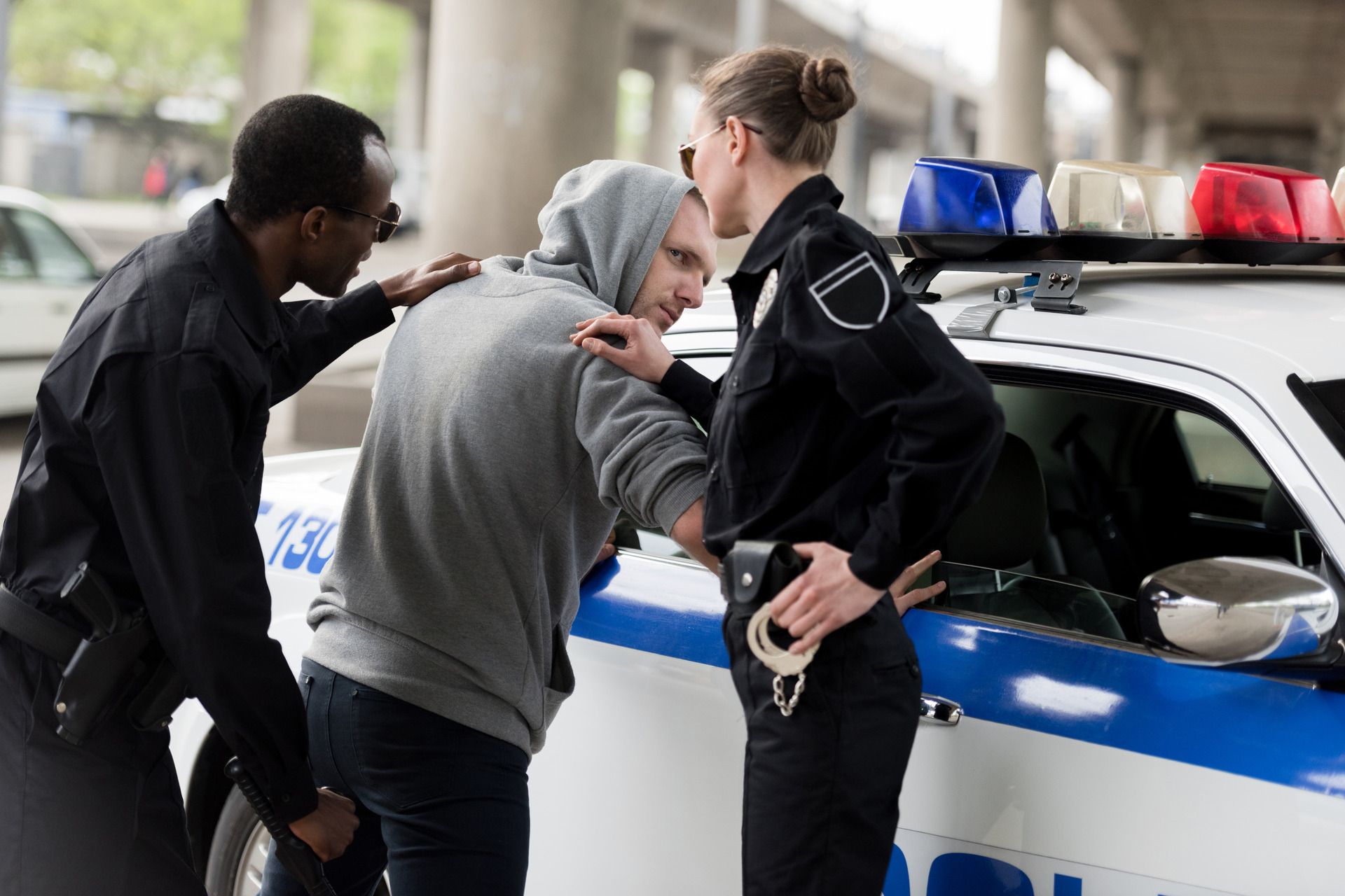 policeman and policewoman arresting young man