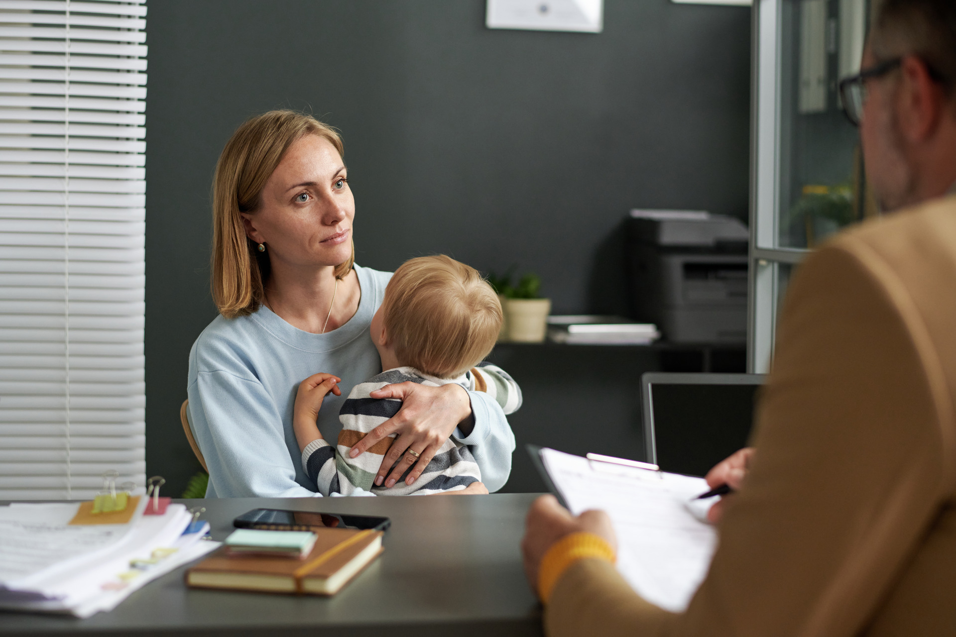 young mom with son having meeting with lawyer