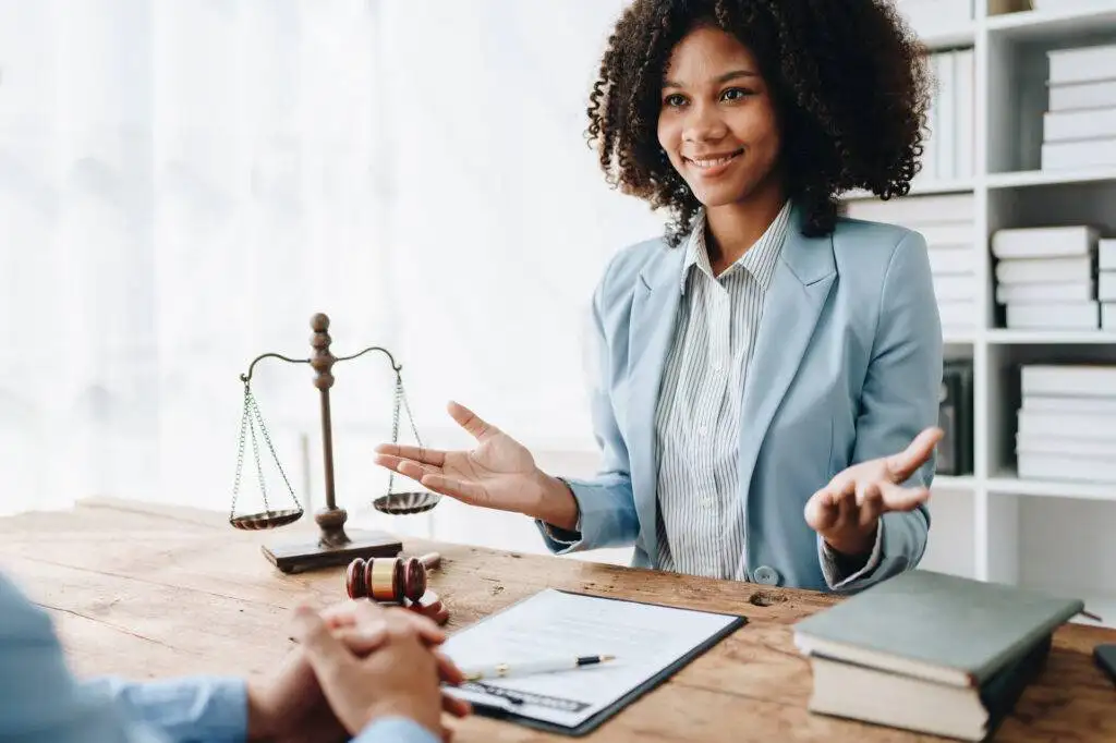 A woman lawyer discusses matters with a client in an office