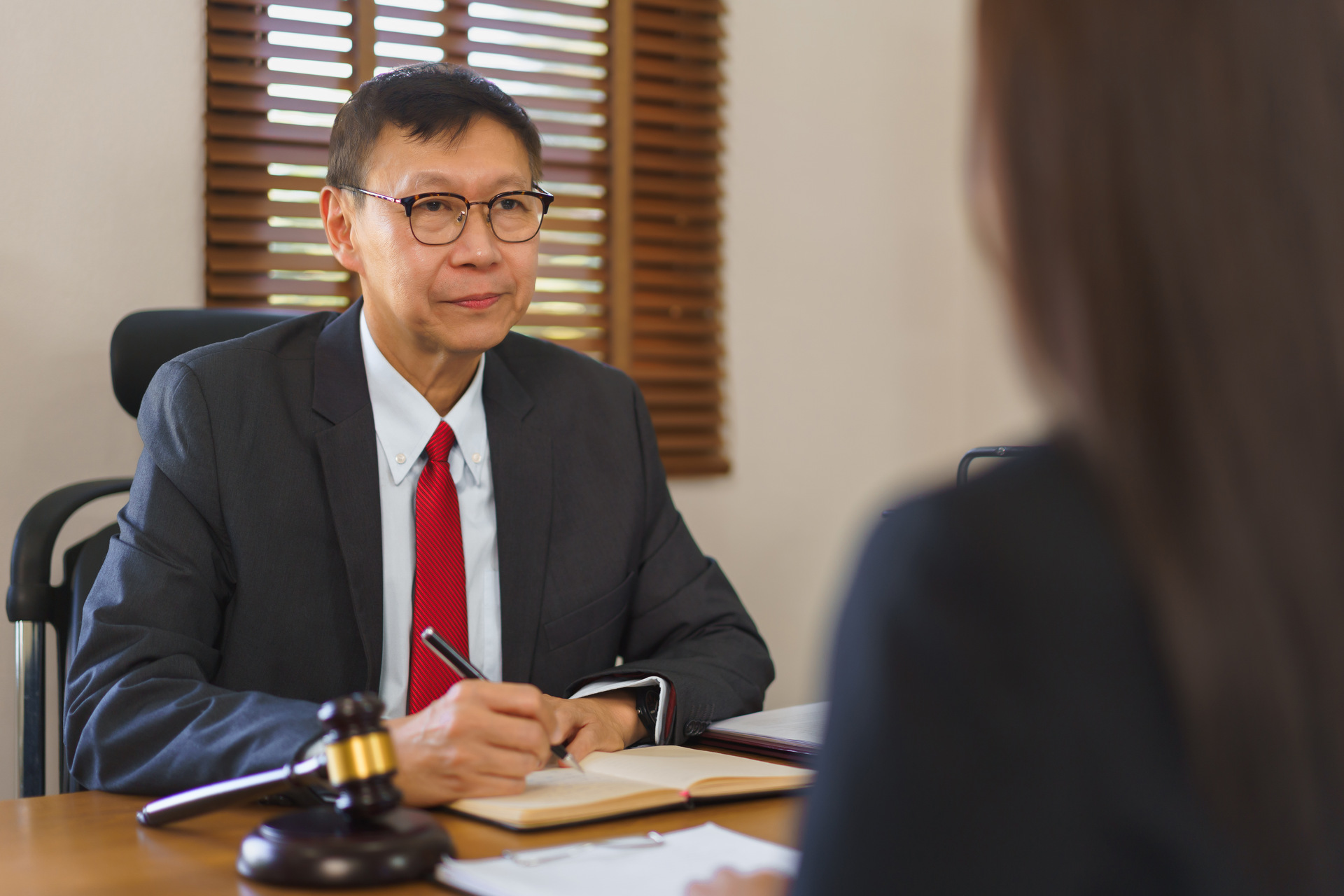 Male lawyer taking notes during client consultation