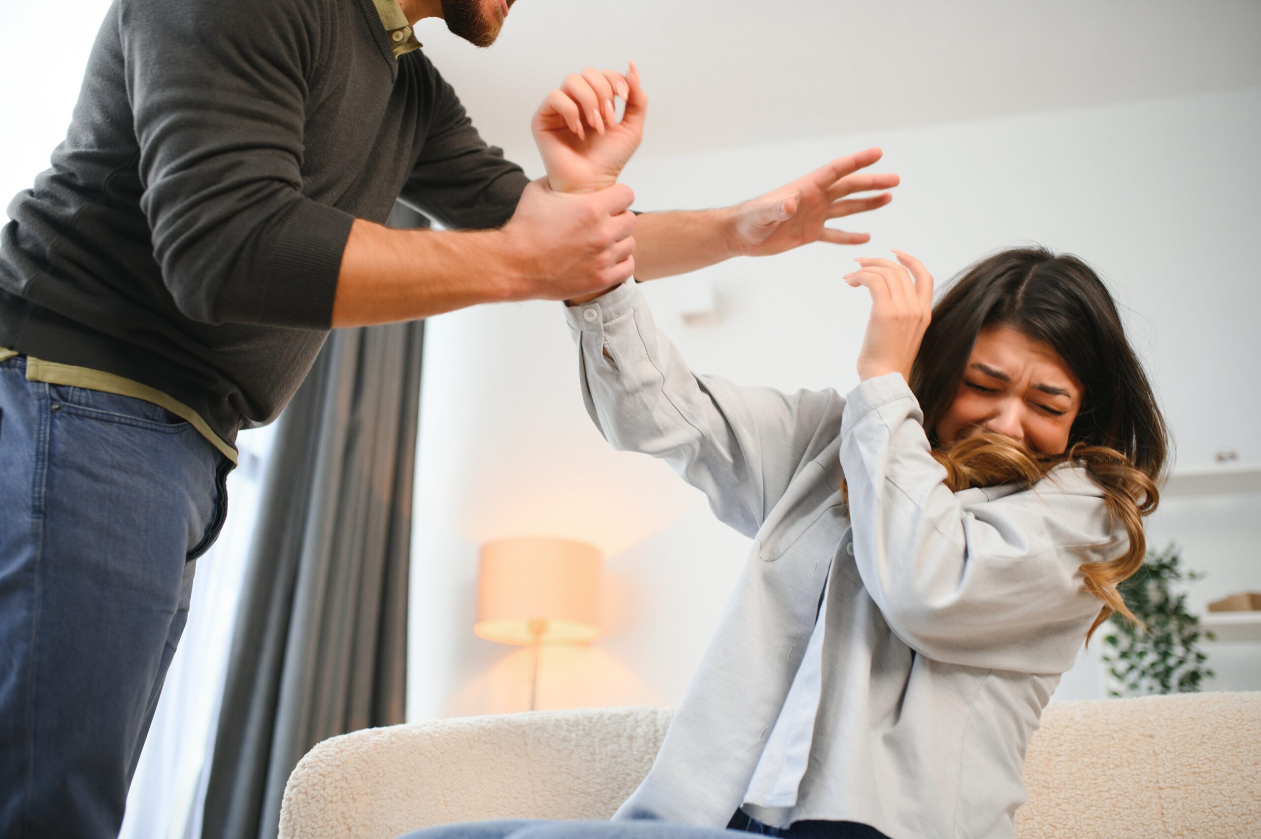 Angry man raises his fist at frightened woman