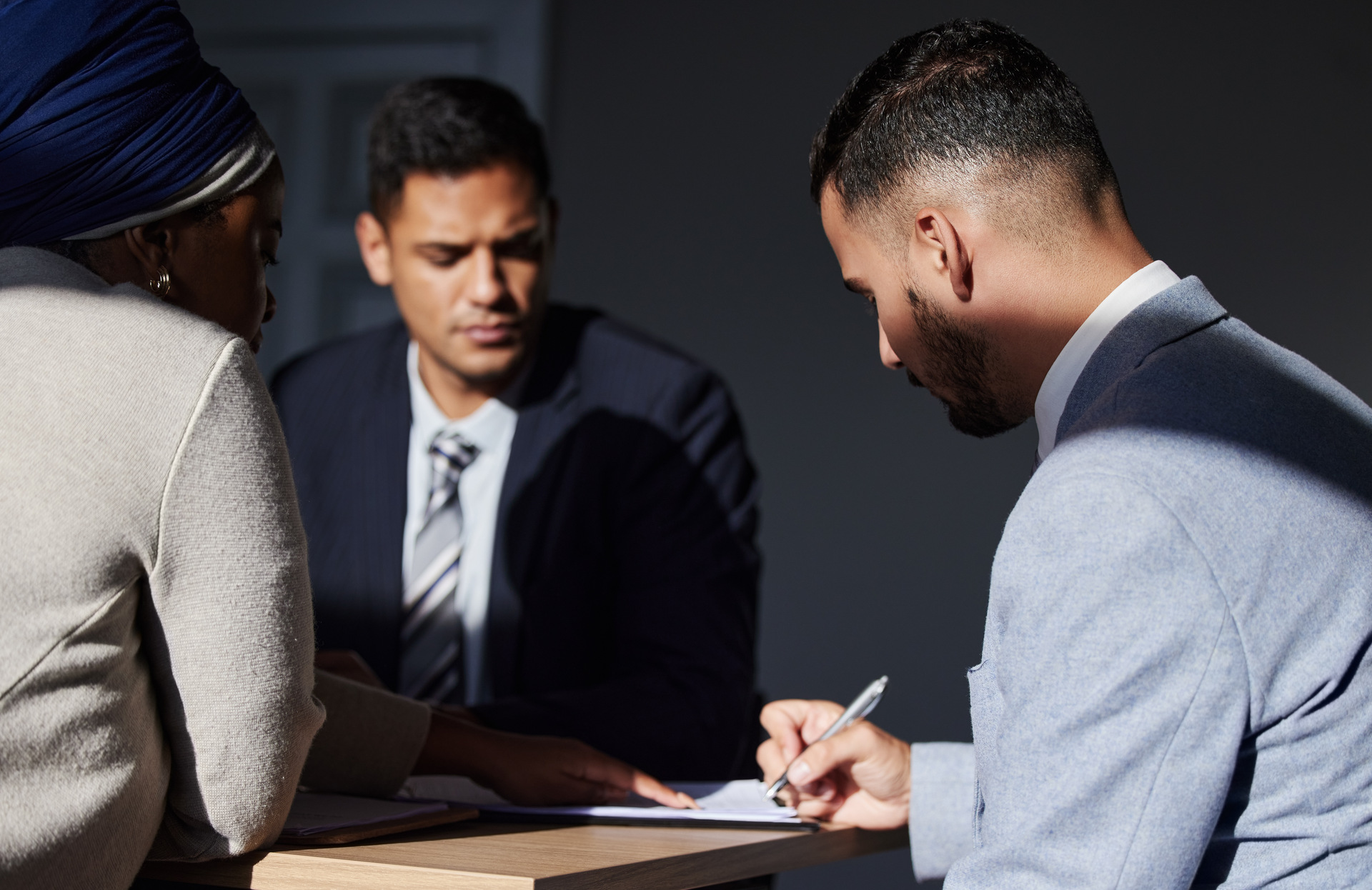 Man and woman signing legal documents with lawyer