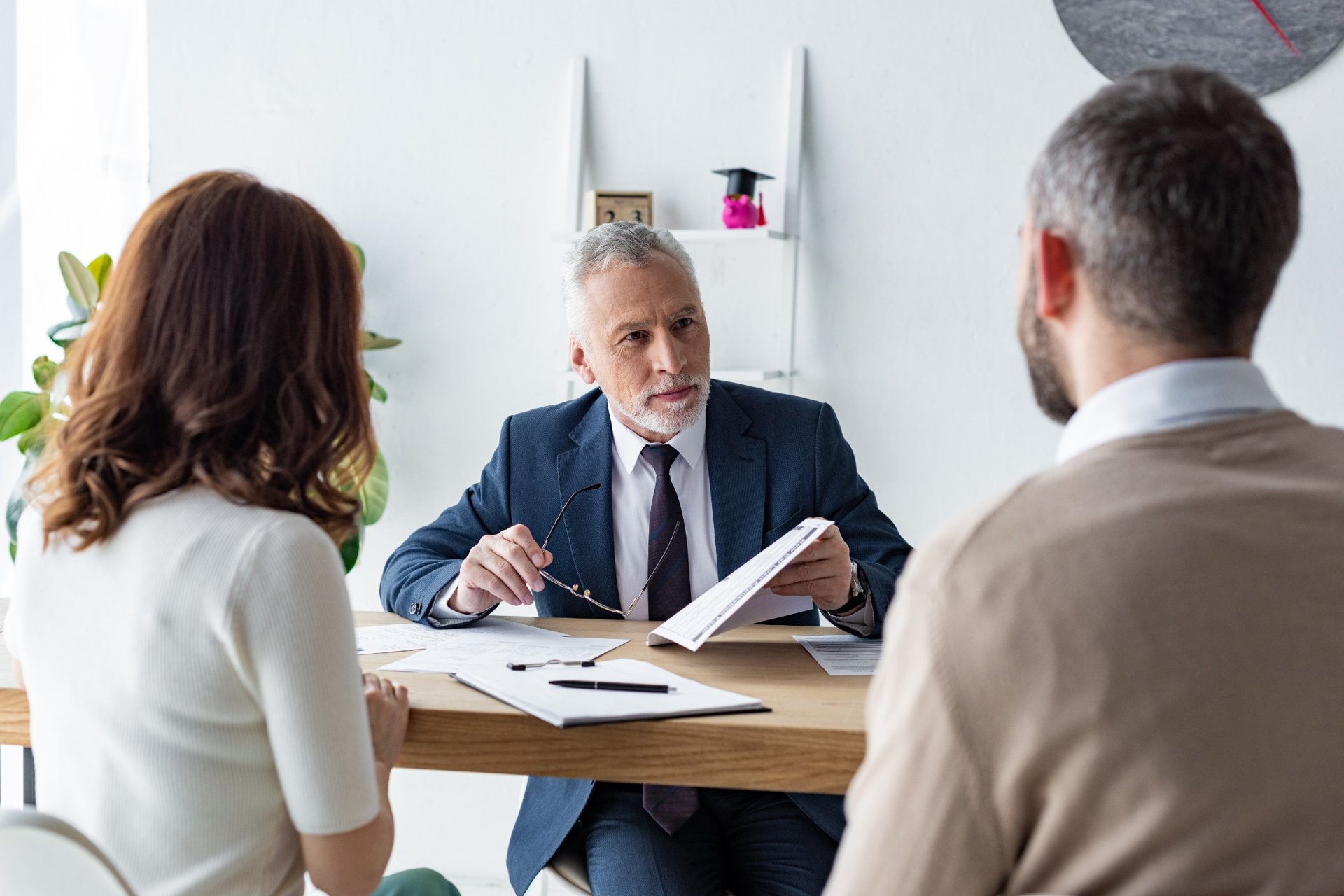 Mature lawyer discussing legal documents with man and woman
