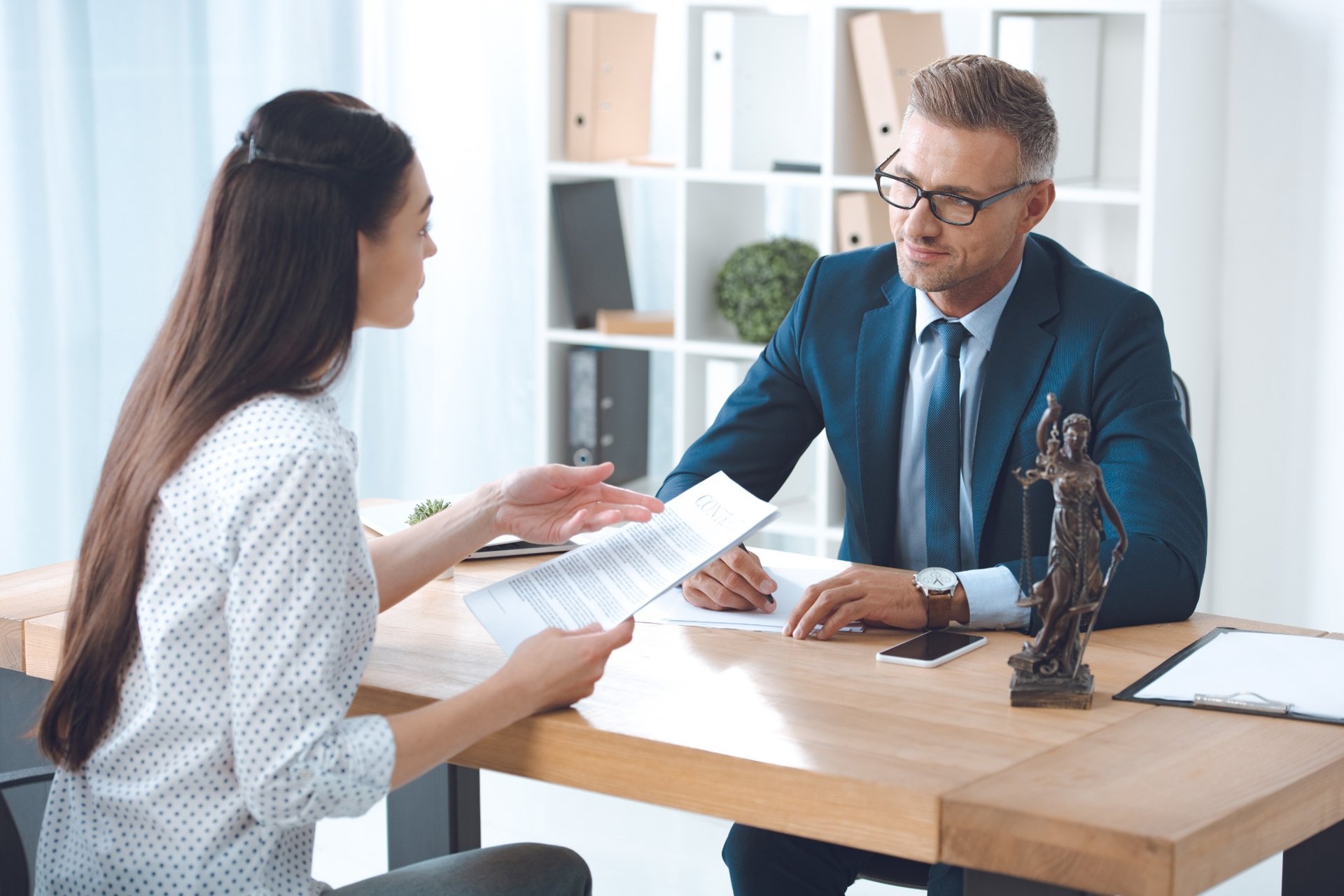 Woman consulting with a male lawyer at an office desk