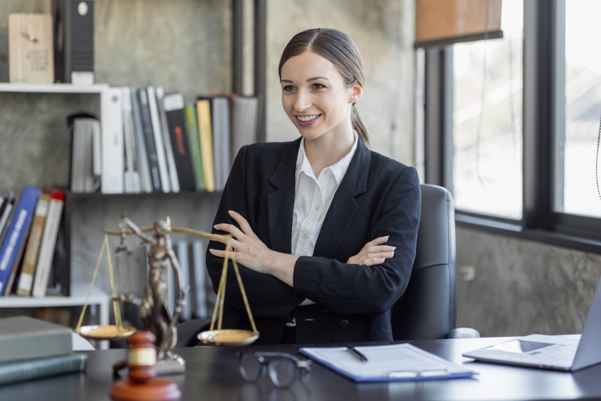 Female lawyer in a suit smiling at her desk
