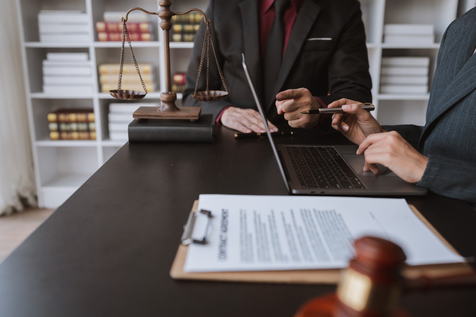Lawyers collaborating at office with legal documents and laptop