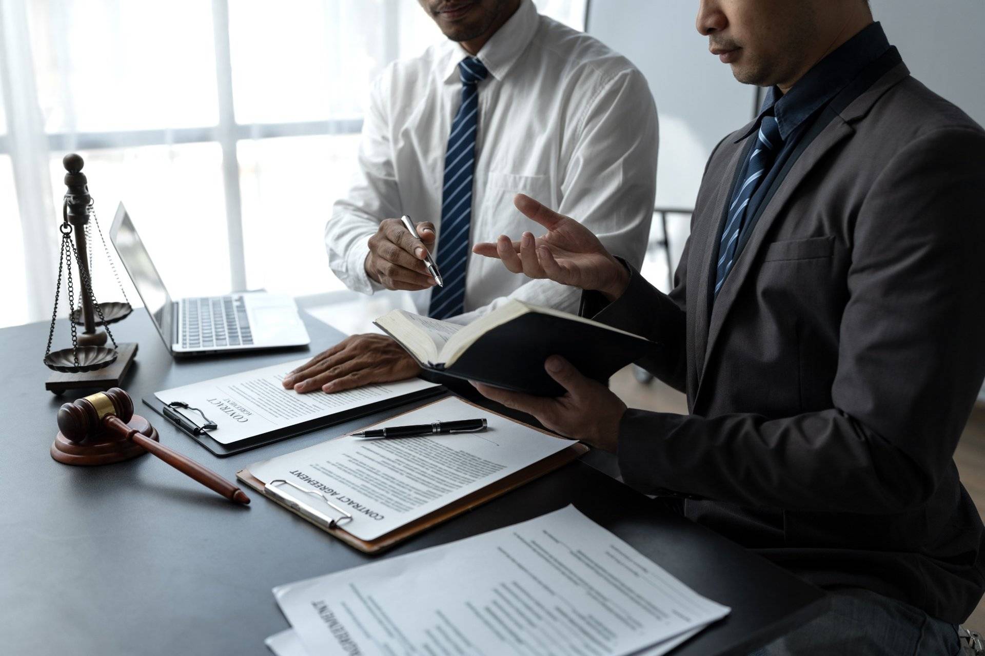 Lawyers reviewing contract and legal documents during meeting