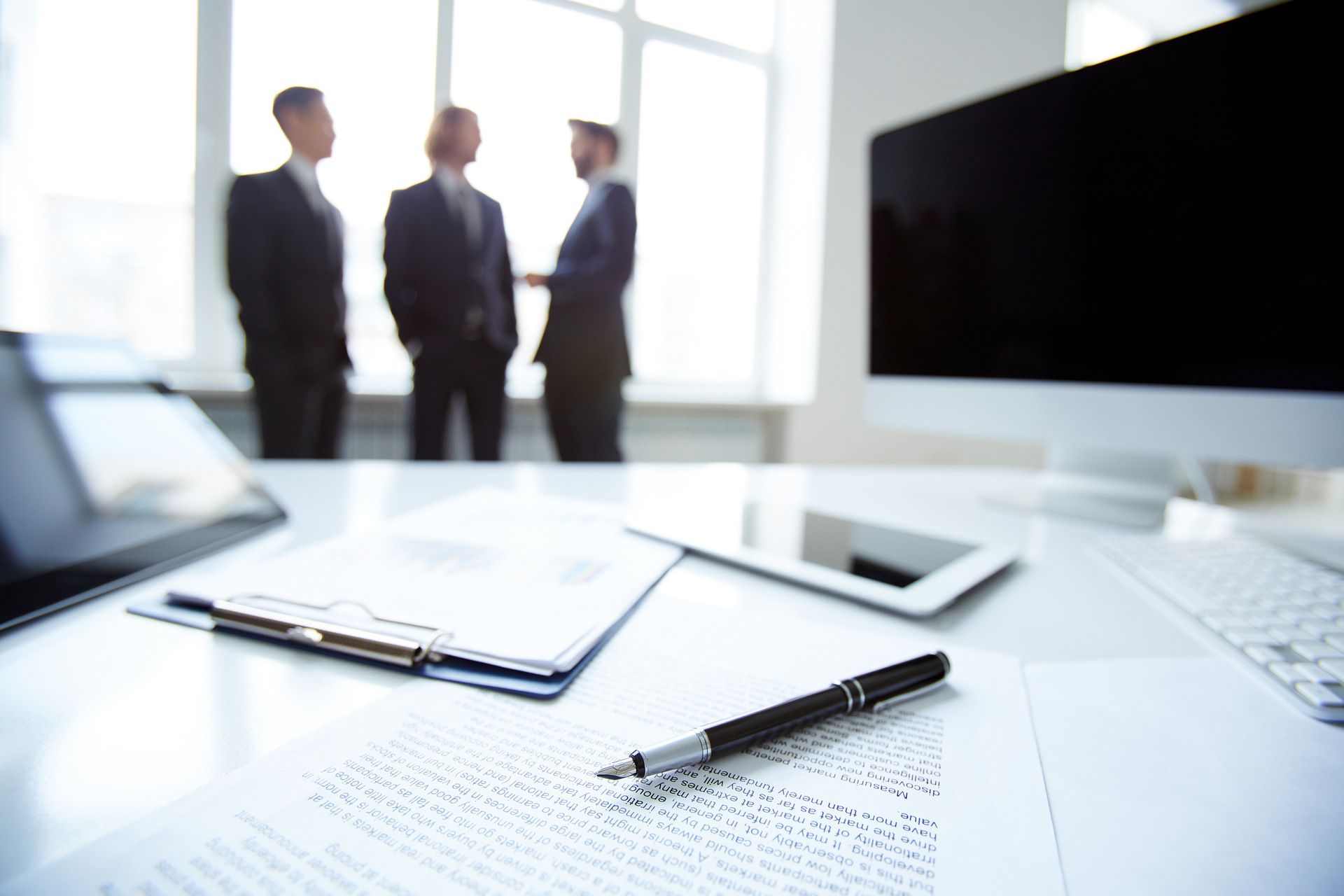 Legal documents on desk with people talking in background