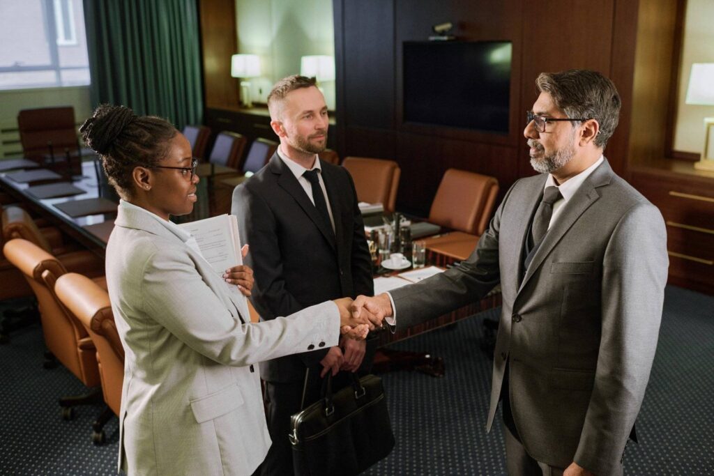 Lawyers shaking hands in a conference room during a legal agreement