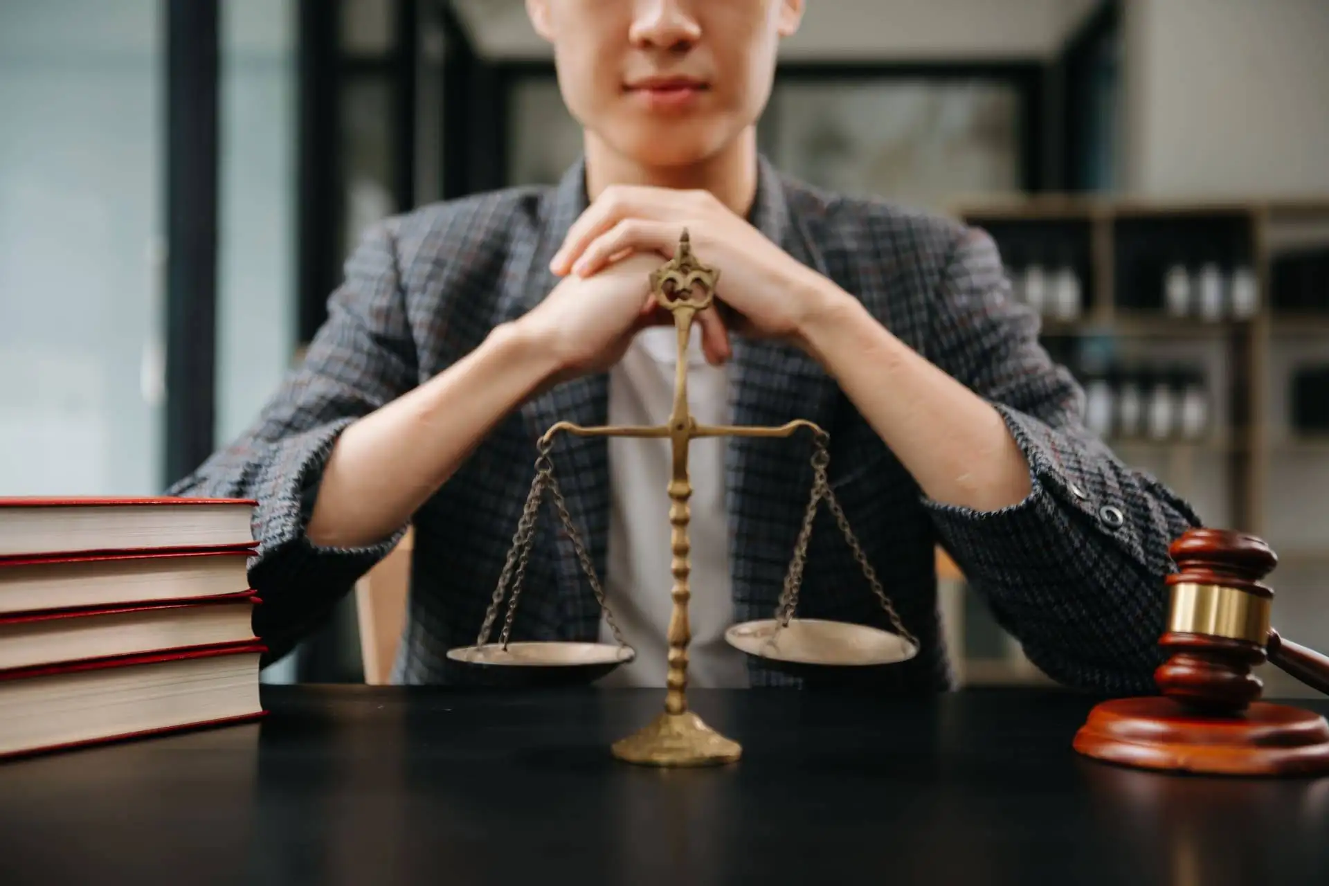 lawyer in the office with brass scale on wooden desk