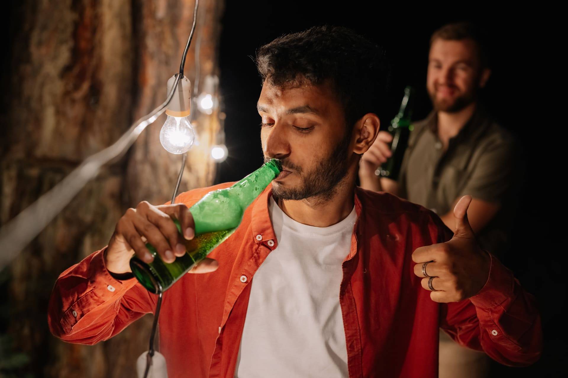 young man drinking beer with friends
