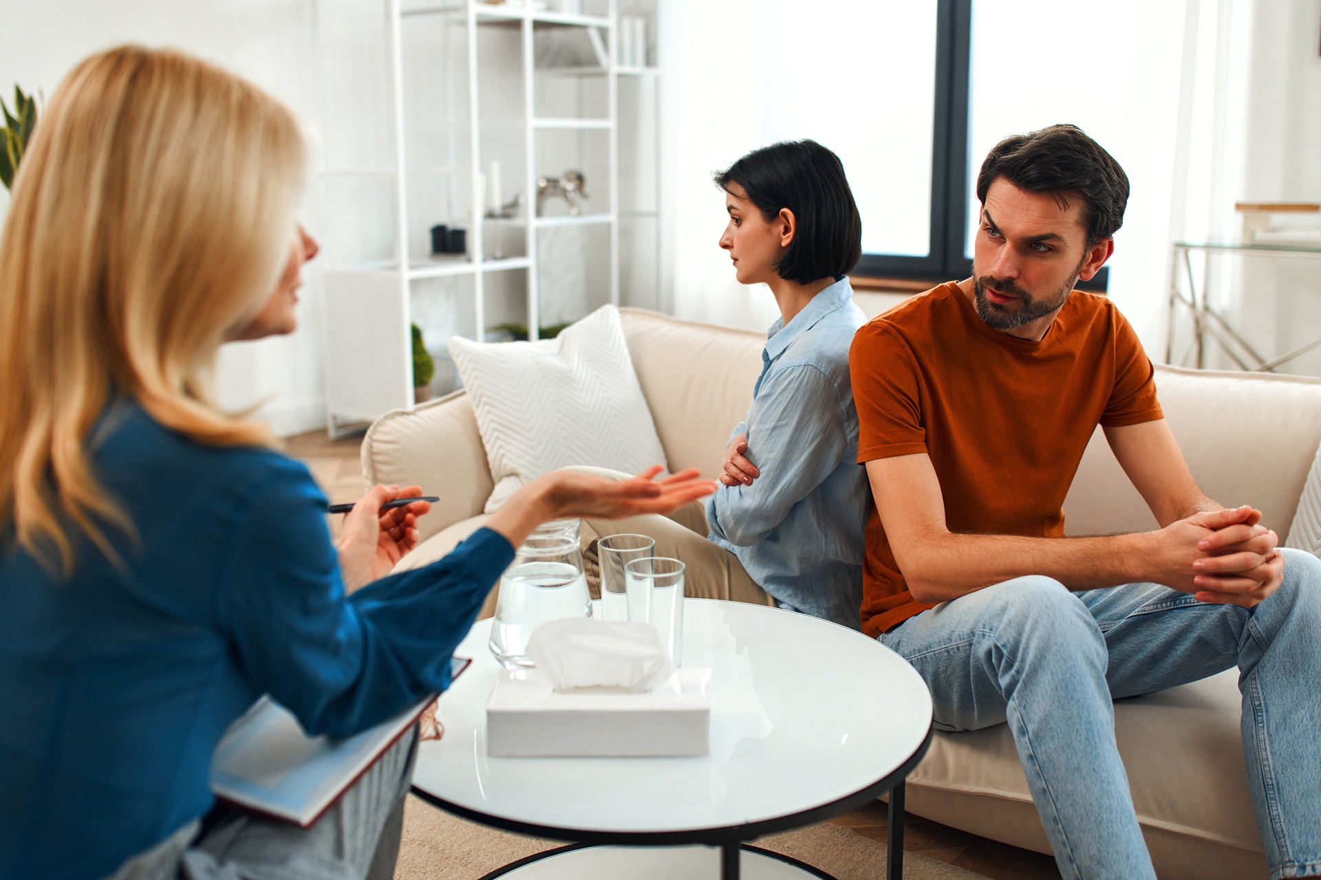 Couple having a serious discussion with a therapist during a counseling session