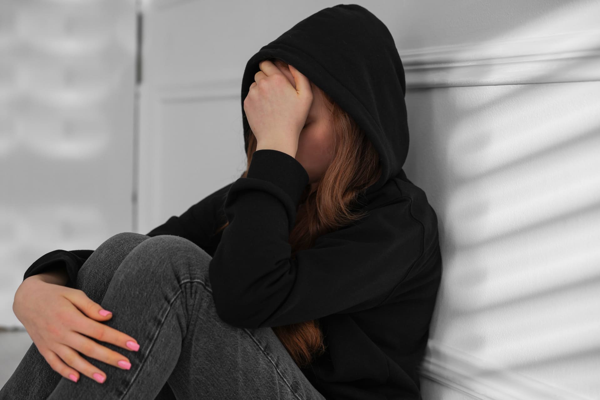 Sad and nervous teenage girl sitting with face burried in hand