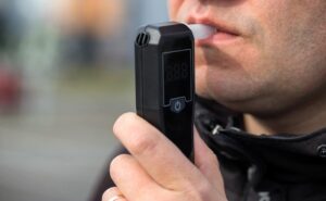 Close-up of man performing a breathalyzer test