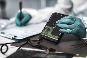 Forensic investigator reviews a physical hard drive for evidence