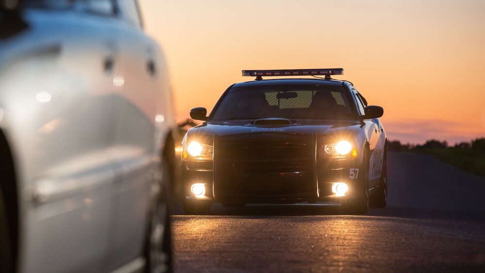 Police vehicle following a car on the highway